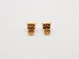 a pair of gold earrings on a white background