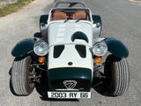 une voiture de sport verte et blanche garée sur le bord de la route