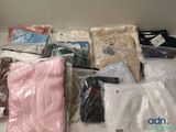 plusieurs sacs de vêtements posés sur une table blanche