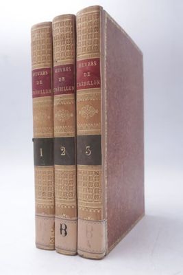 trois livres sont empilés sur une surface blanche