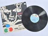 un vieux disque vinyle posé sur une table, à côté d'un CD