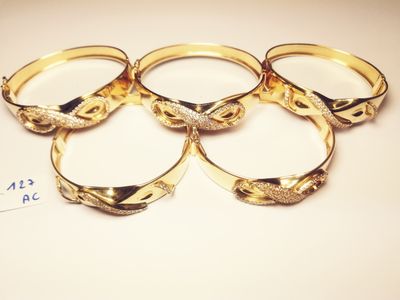 four gold rings with diamonds on them sitting on top of a table