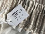 the label is on the pants of a woman who is wearing a striped shirt