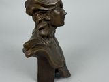 a bronze bust of a man with a hat on his head