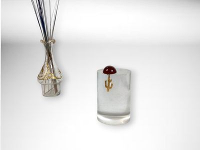 a glass vase with a flower in it next to a vase with sticks