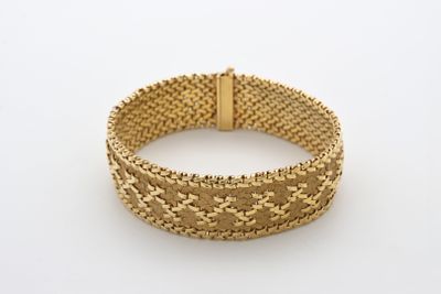un bracelet en maille dorée muni d'un fermoir, sur fond blanc