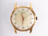 gros plan d'une montre-bracelet en or sur une surface blanche