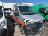 une camionnette argentée garée à côté d'autres camions sur un parking