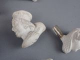 four white ceramic head knobs on a gray surface