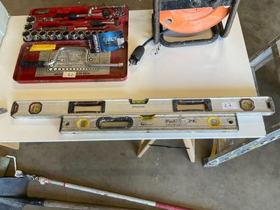 a table with tools and tools on it in a garage