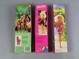 two boxes of barbie dolls are lined up on a table