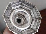 a person holding a silver plate with a black hole in it
