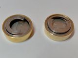 two small metal objects on a white surface