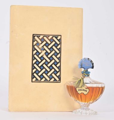un flacon de parfum posé à côté d'un cadre photo sur une table