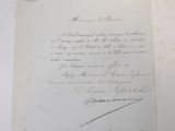an old document with a handwritten letter on it sitting on top of a table
