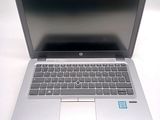 a silver laptop with a black keyboard on a white table