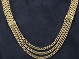 a woman wearing a gold chain necklace and a black shirt