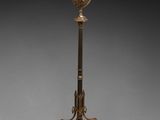 une lampe ancienne en laiton montée sur un trépied et dotée d'un abat-jour en verre
