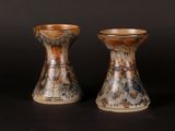 two vases sitting side by side on a black surface