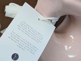 a pink vase that has a tag on it