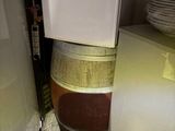 an image of a kitchen with a refrigerator and a stack of wine barrels
