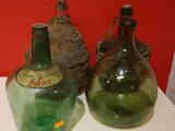 deux bouteilles en verre vert posées sur une table blanche