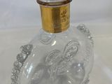 a clear glass bottle with a gold top on a table