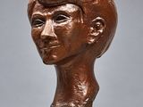 sculpture représentant une tête d'homme sur un socle, avec un fond gris