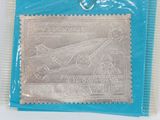 a close up of a silver stamp on a blue bag