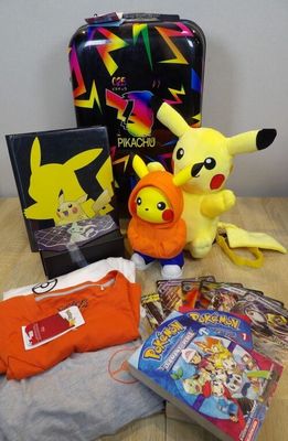 de nombreux objets posés sur la table, notamment un sac à dos, une peluche et une figurine Pokémon