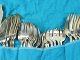 a lot of forks and spoons in a blue bag