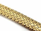 a gold bracelet with a snake skin pattern on it