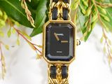 a black and gold watch with a chain around it