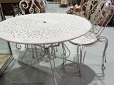 une table et des chaises blanches dans une pièce où il y a beaucoup de meubles