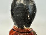 wooden figurine of a man with a black hat and a red shirt