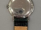 a close up of a watch on a white surface