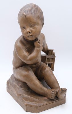 statue of a child sitting on a box with a basket in his hand