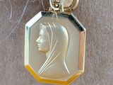 a gold medal with a picture of a woman on it