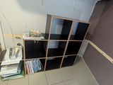 a bookshelf in the corner of a small room