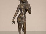 bronze statue of a woman holding a flower in her right hand