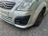 a small silver car parked on the side of the road