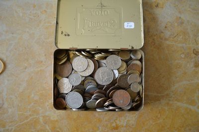 une boîte remplie de pièces de monnaie posée sur une table