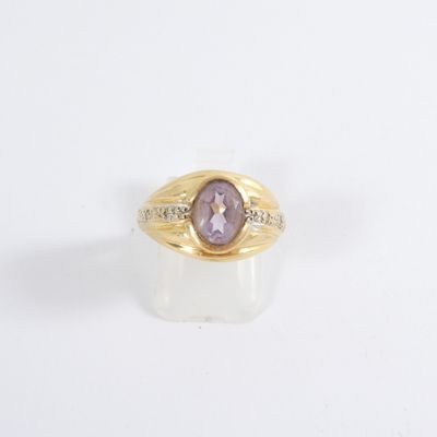 an image of a gold ring with a purple stone in the center
