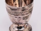 an antique silver goblet on a stand on a white background