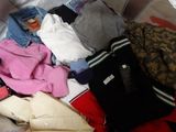 a suitcase full of clothes and clothes on a bed