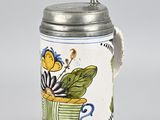 a beer mug with a flower design on it