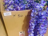 purple flowers in a cardboard box sitting on the floor next to a cardboard box