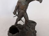 a statue of a man holding a hammer and a bucket