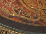 a close up of a red and gold table with a clock on it