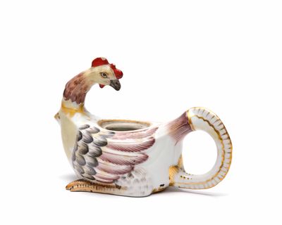 une théière en forme d'oiseau, blanche et rouge, posée sur un fond blanc